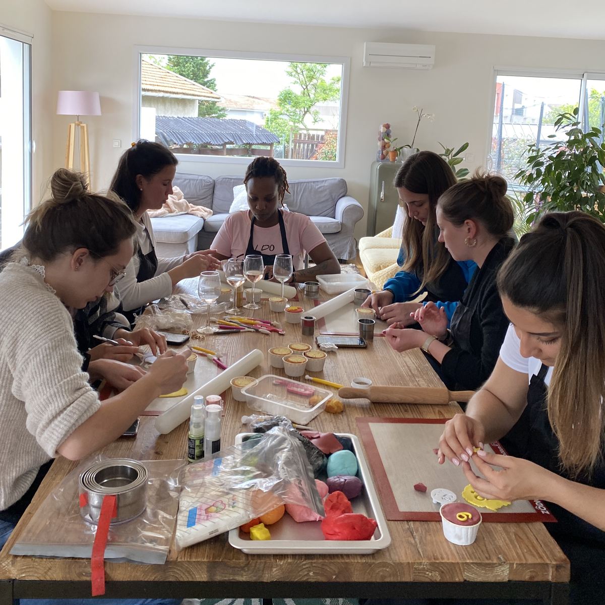 Groupe d'amies qui décorent des cupcakes à la pâte à sucre pendant un atelier Harry Potter