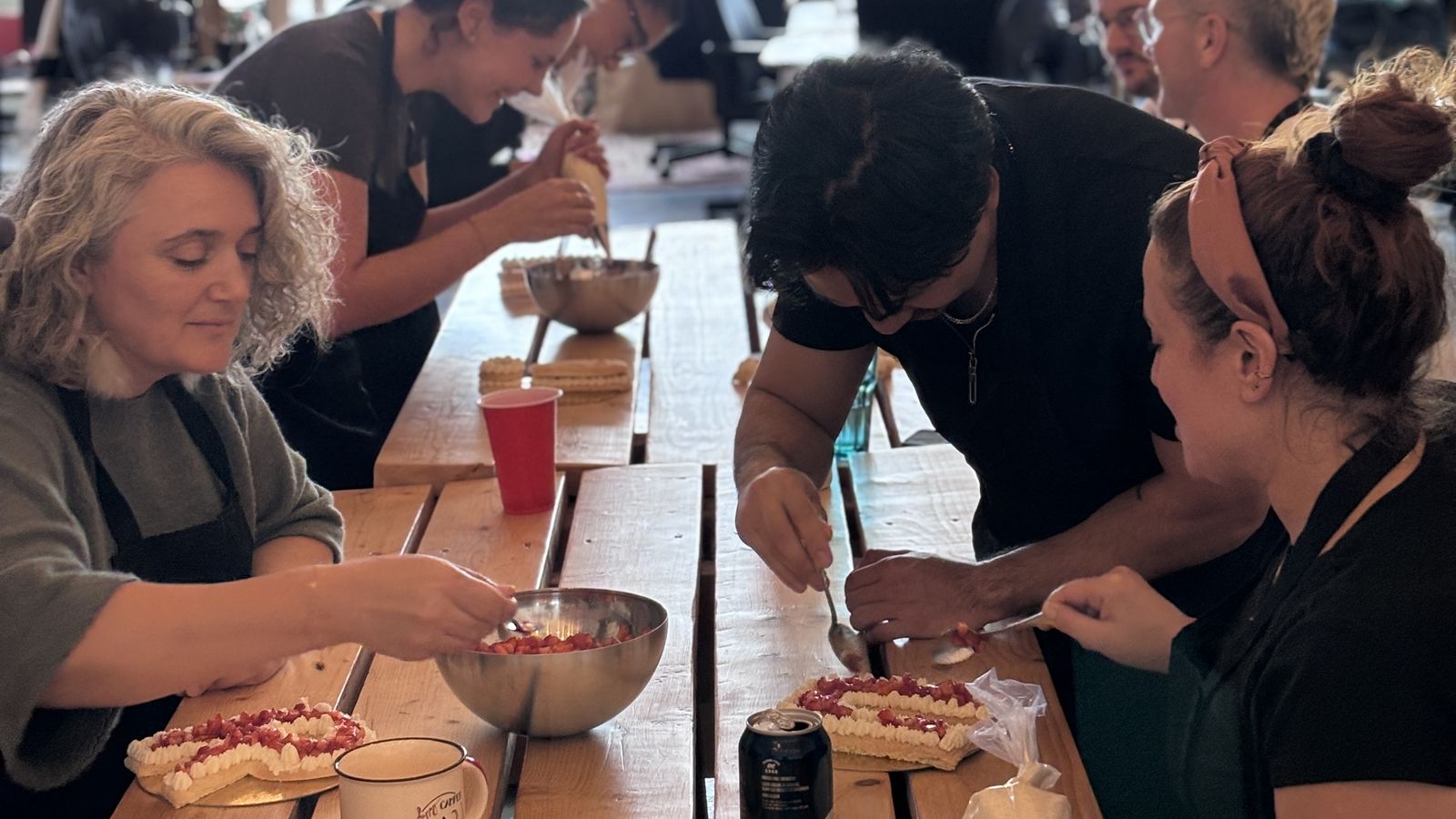 Équipe réunie autour des tables pour un atelier de pâtisserie dans ses bureaux à Montréal