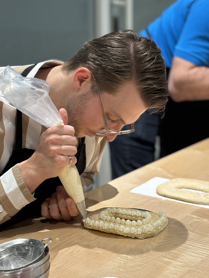 Participant qui décore son gâteau à la poche à douille lors d'un party de Noël d'entreprise à Montréal