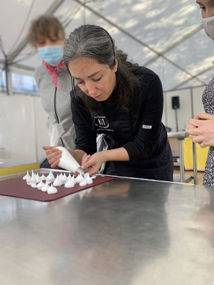 Pascaline montre le pochage des meringues à la poche à douille pendant un atelier